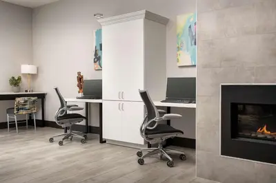 a office with two desks and a fireplace at Home2 Suites by Hilton Denver Central Park in Denver