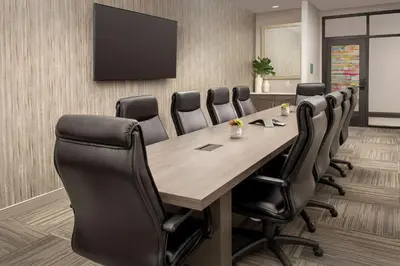 a conference room with a wooden table and leather chairs at Home2 Suites by Hilton Denver Central Park in Denver