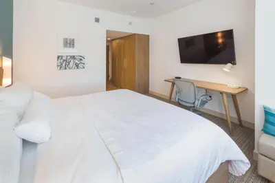 a bedroom with a white bed and a desk at Element Denver International Airport in Denver