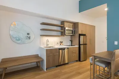 a kitchen with wooden cabinets and a sink and a refrigerator at Element Denver International Airport in Denver