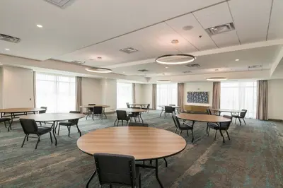 a large room with tables and chairs and windows at Element Denver International Airport in Denver