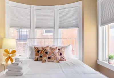 a bedroom with a white bed with a window at Stunning Historic Home - DT Location! - Sleeps 8 in Denver