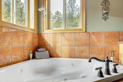 a bath tub in a bathroom with two windows at Secluded & Spacious Mountain Getaway in Morrison