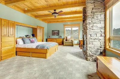a bedroom with a bed and a stone wall at Secluded & Spacious Mountain Getaway in Morrison