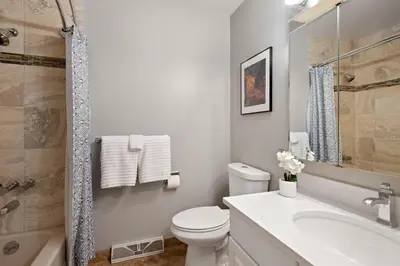 a white bathroom with a toilet and a sink at Relaxing Escape + Large Deck - 12 Min to Red Rocks in Lakewood