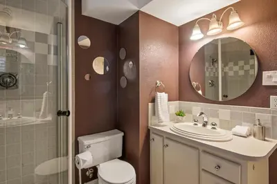 a bathroom with a toilet and a sink and a mirror at Relaxing Escape + Large Deck - 12 Min to Red Rocks in Lakewood