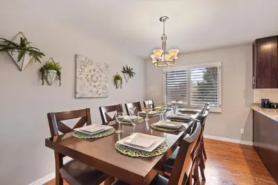 a dining room with a wooden table and chairs at Relaxing Escape + Large Deck - 12 Min to Red Rocks in Lakewood