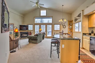 a kitchen and living room with a couch and a table at 10 Mi to Breckenridge Townhome with Hot Tub and Deck! in Frisco