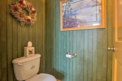 a bathroom with a toilet with a wreath on the wall at 10 Mi to Breckenridge Townhome with Hot Tub and Deck! in Frisco