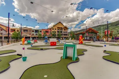 an empty playground with miniature golf courses in a town at Premier 2 Bedroom Mountain Condo In River Run Village With Expansive Mountain Views And Walking Distance To Ski Slopes in Keystone