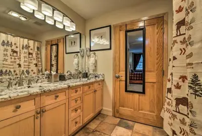 a bathroom with two sinks and a wooden door at Premier 2 Bedroom Mountain Condo In River Run Village With Expansive Mountain Views And Walking Distance To Ski Slopes in Keystone