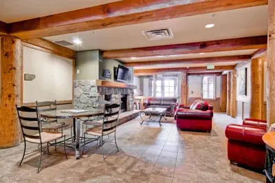 a living room with a table and chairs and a fireplace at Premier 2 Bedroom Mountain Condo In River Run Village With Expansive Mountain Views And Walking Distance To Ski Slopes in Keystone