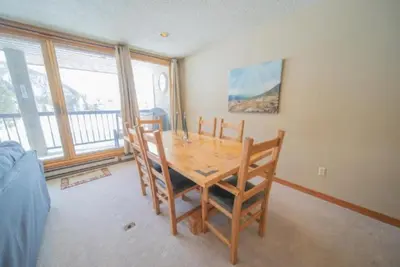 a dining room with a wooden table and chairs at 2 Bedroom Mountain Condo In Lakeside Village Near Keystone Lake With Complimentary Shuttle Service in Keystone