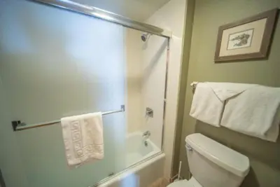 a bathroom with a toilet and a shower with towels at 2 Bedroom Mountain Condo In Lakeside Village Near Keystone Lake With Complimentary Shuttle Service in Keystone