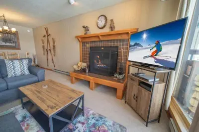a living room with a large television and a living room with at 2 Bedroom Mountain Condo In Lakeside Village Near Keystone Lake With Complimentary Shuttle Service in Keystone