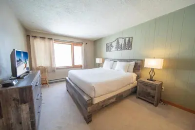 a bedroom with a bed and a television in it at 2 Bedroom Mountain Condo In Lakeside Village Near Keystone Lake With Complimentary Shuttle Service in Keystone