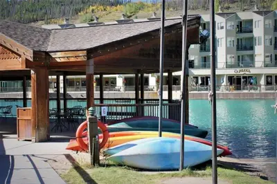 a group of boats parked under a pavilion next to the water at Lakeside Village 4 Bedroom Condo in Keystone