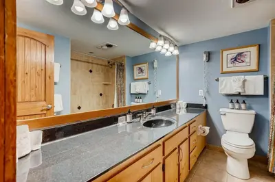 a bathroom with a sink and a toilet and a mirror at Lakeside Village 4 Bedroom Condo in Keystone