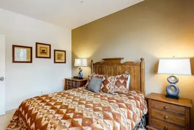 a bedroom with a large bed and two night stands at Seasons 3 Bedroom Townhome At Lakeside Village in Keystone
