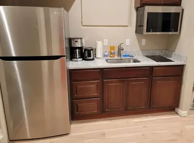 a kitchen with a stainless steel refrigerator and a sink at Jule Sleep in Denver