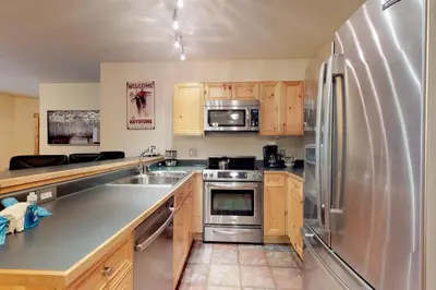 a large kitchen with a stainless steel refrigerator at Tenderfoot Lodge 2 Bedroom In Keystone in Keystone