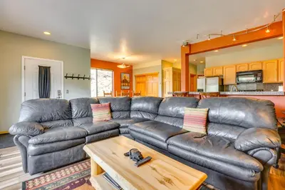 a living room with a leather couch and a table at Cozy Condo with Views, 3 Mi to Winter Park Resort! in Winter Park