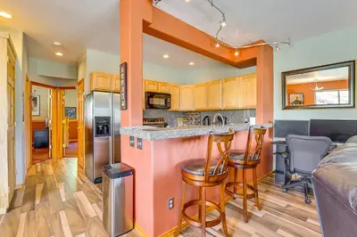 a kitchen with a bar and a living room at Cozy Condo with Views, 3 Mi to Winter Park Resort! in Winter Park