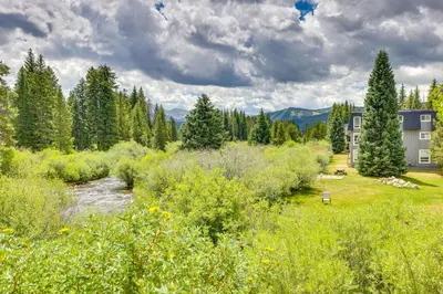 a house in a field with a river and trees at Cozy Condo with Views, 3 Mi to Winter Park Resort! in Winter Park