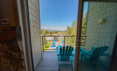 a balcony with chairs and a table and a pool at 1 Bedroom Mountain Condo In Lakeside Village Near Keystone Lake With Complimentary Shuttle Service in Keystone