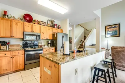 a kitchen with wooden cabinets and a counter top at Luxury 3 Bedroom Townhouse Next To Keystone Lake, Free Shuttle, Hot Tub And Sauna in Keystone