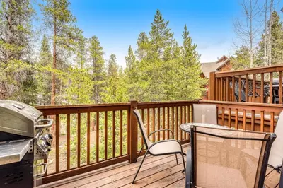 a patio with a grill and a table and chairs on a deck at Luxury 3 Bedroom Townhouse Next To Keystone Lake, Free Shuttle, Hot Tub And Sauna in Keystone