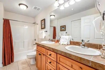 a bathroom with two sinks and a shower and a toilet at Luxury 3 Bedroom Townhouse Next To Keystone Lake, Free Shuttle, Hot Tub And Sauna in Keystone