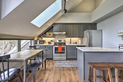 a kitchen with gray cabinets and a table and chairs at Hot Tub and Ski Shuttle Access Keystone Condo! in Keystone