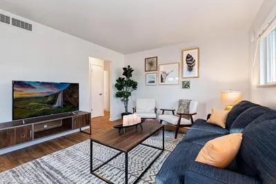 a living room with a blue couch and a tv at Centrally Located Townhome Near PVH - Dog Friendly in Fort Collins