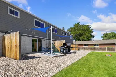 a backyard with a house with a grill and a lawn at Comfortable Abode Near Historic Downtown in Loveland