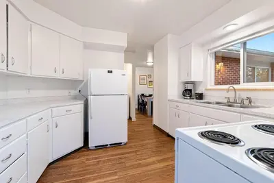 a kitchen with white cabinets and a white refrigerator at Stylish Getaway with Designer Touches - Free Bikes in Fort Collins