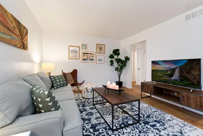 a living room with a couch and a flat screen tv at Couples Getaway - Dog Friendly, Bike to Old Town! in Fort Collins