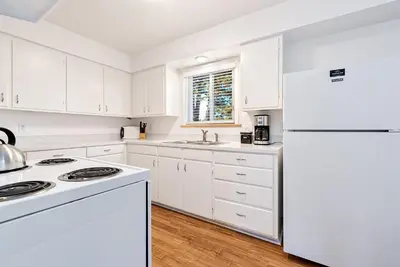 a white kitchen with white appliances and a white refrigerator at Couples Getaway - Dog Friendly, Bike to Old Town! in Fort Collins