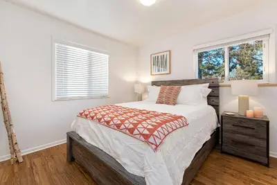 a bedroom with a large bed and two windows at Couples Getaway - Dog Friendly, Bike to Old Town! in Fort Collins