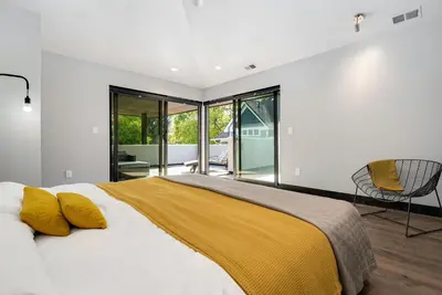 a bedroom with a large bed with a yellow blanket at Relaxing in Paradise with Private Rooftop Deck! in Fort Collins