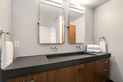 a bathroom with a sink and two mirrors at Relaxing in Paradise with Private Rooftop Deck! in Fort Collins