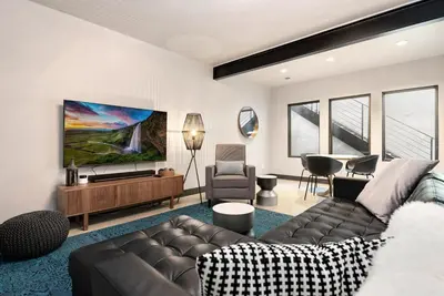 a living room with a couch and a flat screen tv at Relaxing in Paradise with Private Rooftop Deck! in Fort Collins