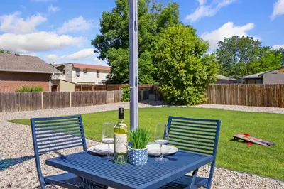 a blue table with two chairs and a bottle of wine at Comfortable Home - Close to Rocky Mtn National Park in Loveland