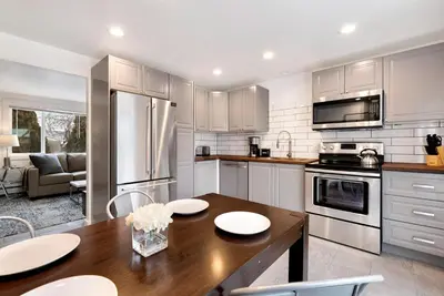 a kitchen with a wooden table and a refrigerator at Comfortable Home - Close to Rocky Mtn National Park in Loveland