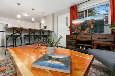 a living room with a table and a tv at Modern & Chic Condo in the Heart of Old Town in Fort Collins