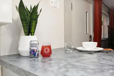 a table with a drink and a vase with a plant at Modern & Chic Condo in the Heart of Old Town in Fort Collins