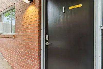 a black door with a sign on it next to a brick building at Contemporary condo in the heart of Old Town in Fort Collins
