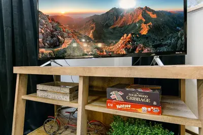 a tv on a wooden stand with a television on it at Contemporary condo in the heart of Old Town in Fort Collins