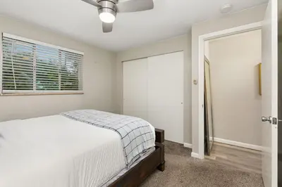 a bedroom with a bed and a ceiling fan at Stunning Downtown Condo - 5 min walk to Old Town! in Fort Collins