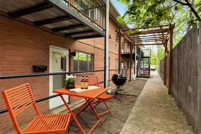 a patio with a table and chairs and a grill at Stunning Downtown Condo - 5 min walk to Old Town! in Fort Collins